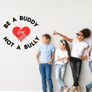 Be A Buddy, Not A Bully Wall Decal that surrounds a heart shape made from two hands and displayed next to buddys of the month at school. By The Simple Stencil