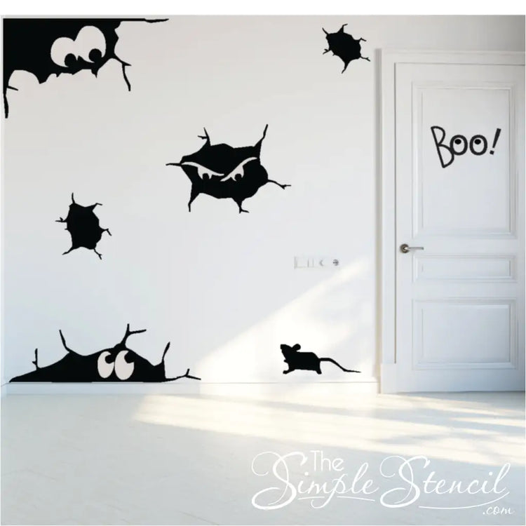 A white door and walls decorated for Halloween with black vinyl decals of a rat, cracks, and peering eyes. The Simple Stencil decals shown in size Large using Matte Black color