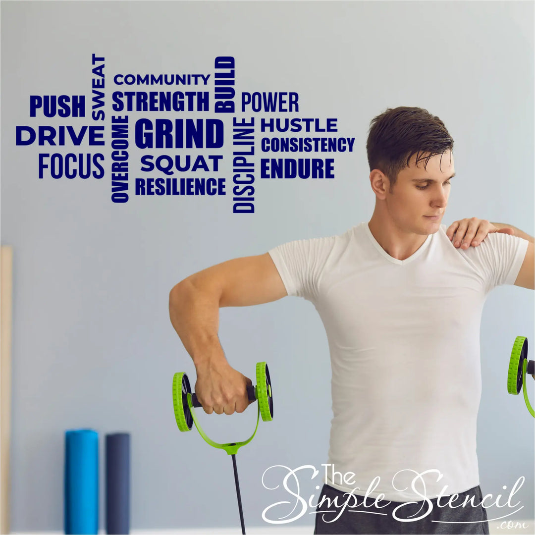 Navy blue motivational gym word wall decal set applied to a light blue wall behind a man training with resistance equipment in a physical therapy room.