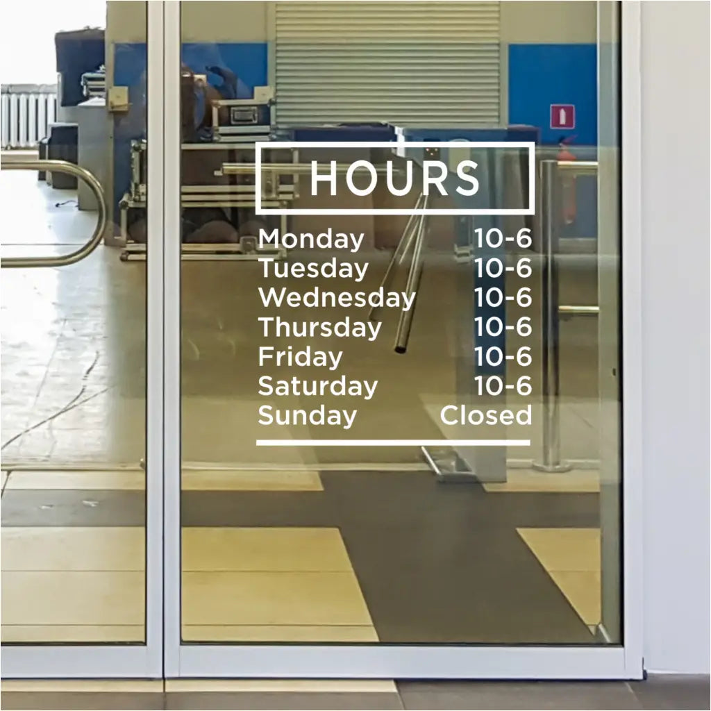 Modern office building with a custom business hours decal displayed on the glass entrance.