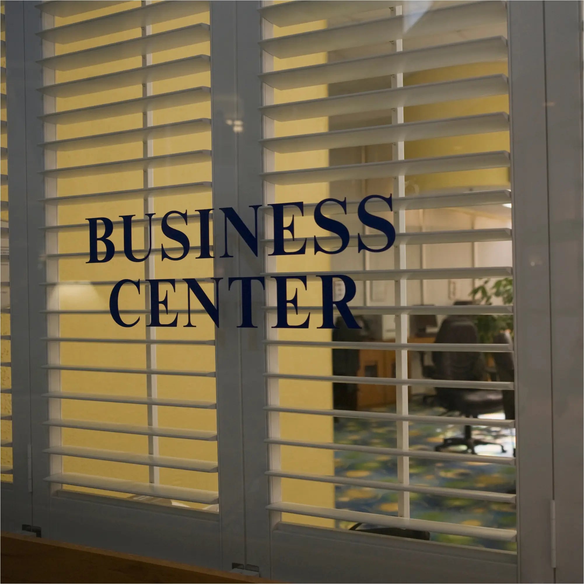 White plantation shutters with a high quality low cost business center decal in dark blue for custom business doors