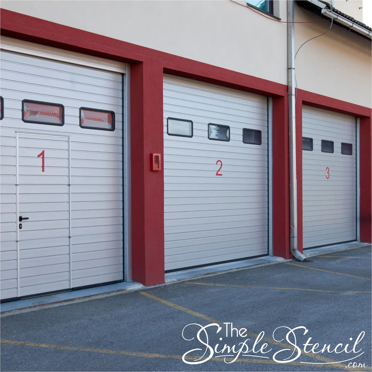 White segmented garage doors with red trim featuring high quality custom name decals for business doors low cost decals now