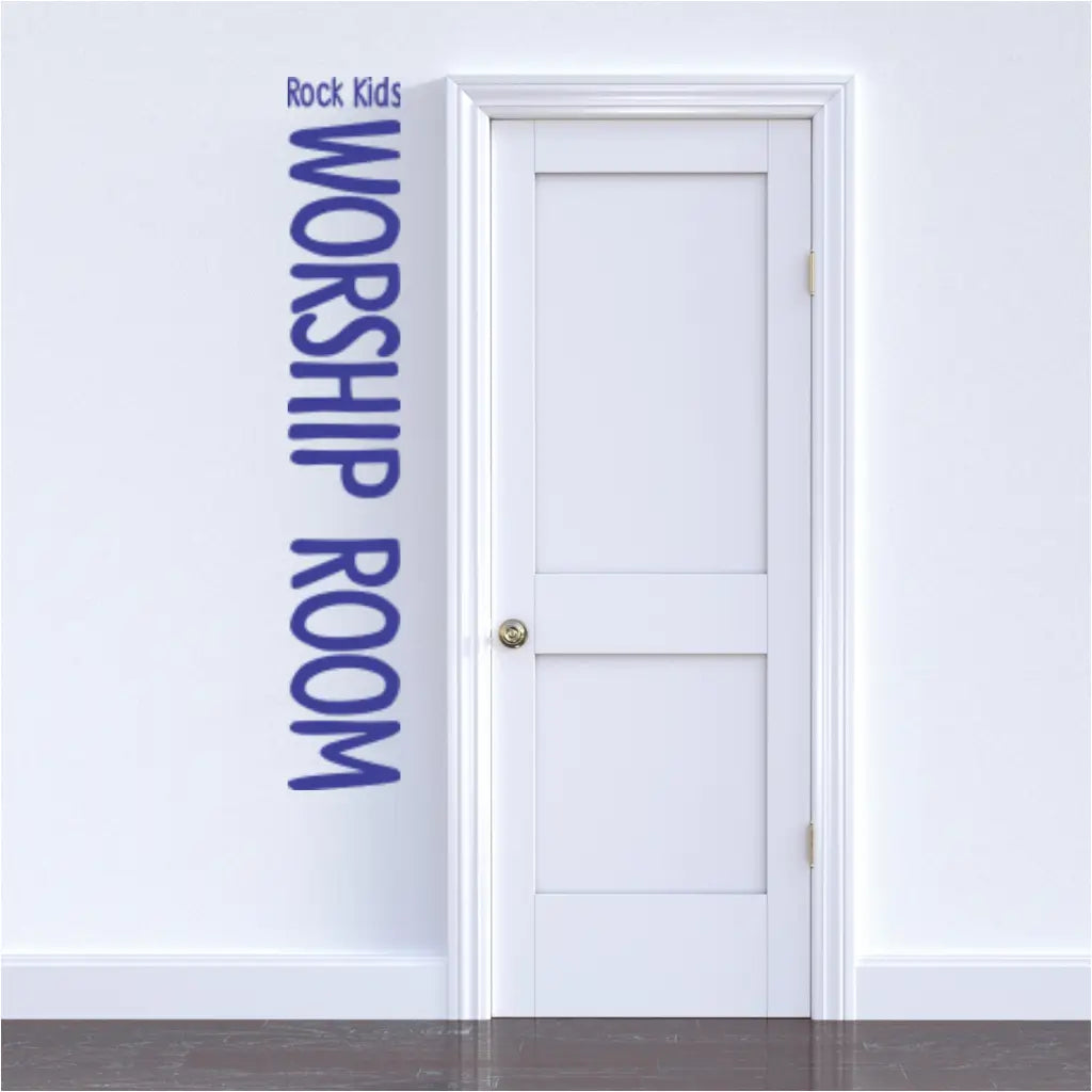 Blue vinyl decal with the words "WORSHIP ROOM" displayed vertically next to a closed wooden door labeled "Rock Kids Worship Room" in a church hallway. (The Simple Stencil)