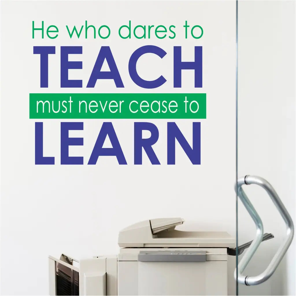 Vinyl decal with inspiring text "He who dares to teach must never cease to learn" displayed on a colorful teacher's lounge wall. By The Simple Stencil