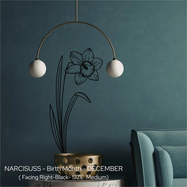 A black Narcissus birth flower wall etching applied vertically behind a modern mobile light fixture on a dark teal wall.