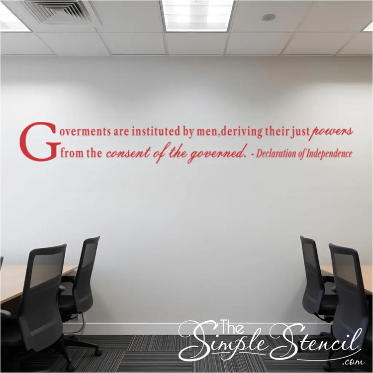 Red wall decal of a quote from the Declaration of Independence, reading "Governments are instituted by men, deriving their just powers from the consent of the governed." The decal is installed in a modern office or conference room with tables and chairs.