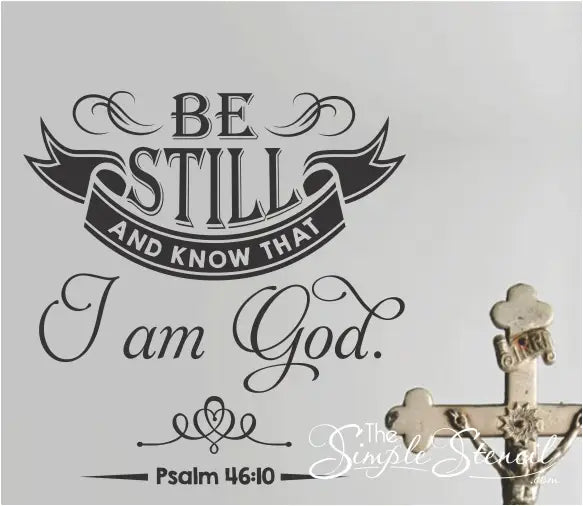 "Be still and know that I am God" wall decal with elegant flourishes displayed in a home living room.