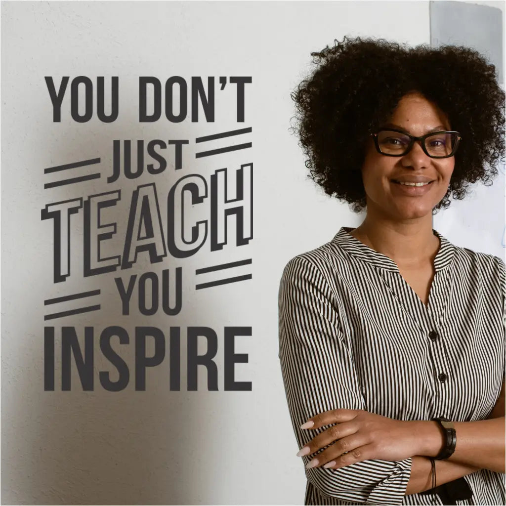 A teacher reading the "You Don't Just Teach, You Inspire" wall decal.