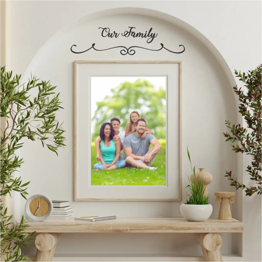 "Our Family" wall decal displayed on a living room wall entry alcove where a family picture is displayed. 