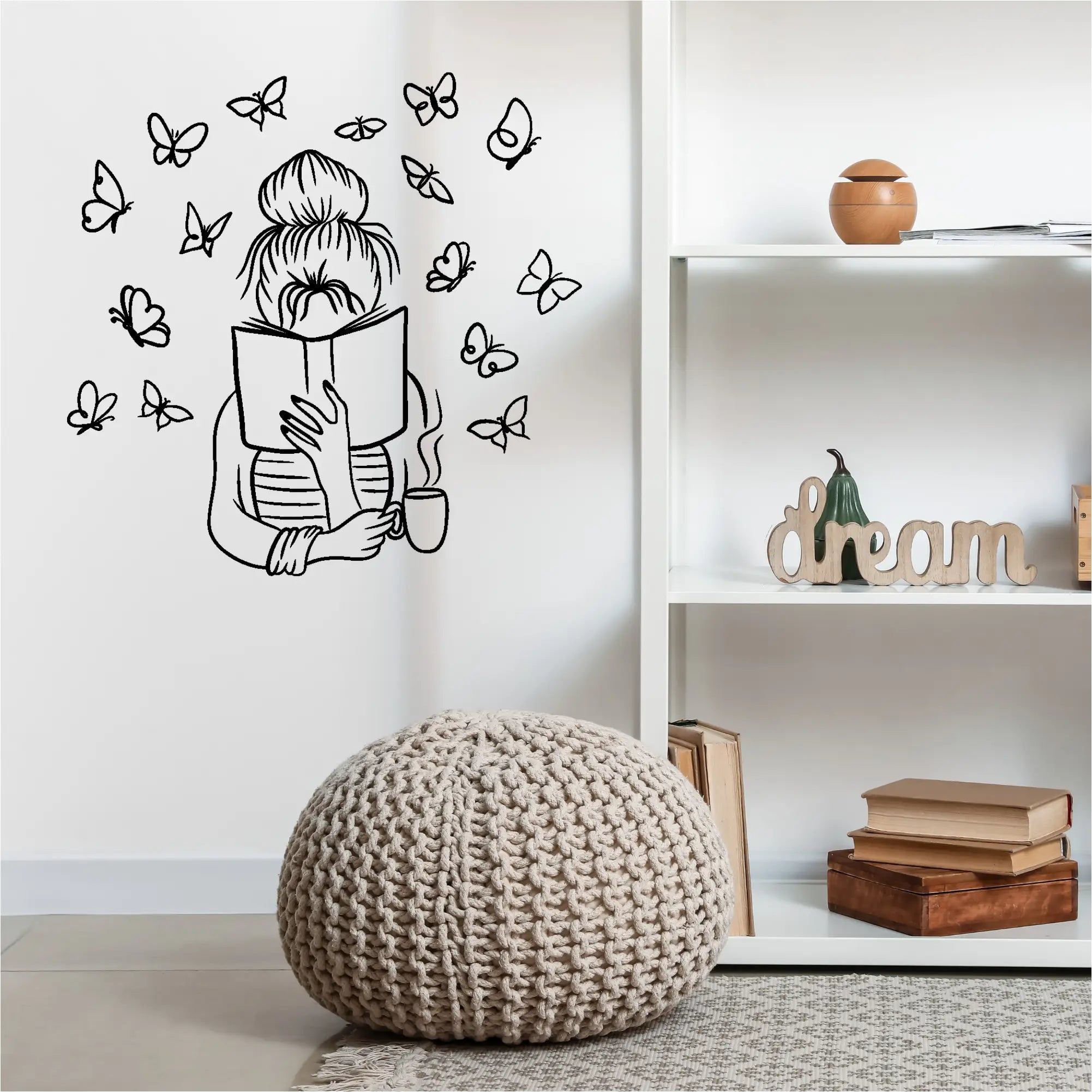 Beige knitted pouf with textured chunky knit pattern complementing wall decal featuring enchanting butterfly girl for home reading nooks