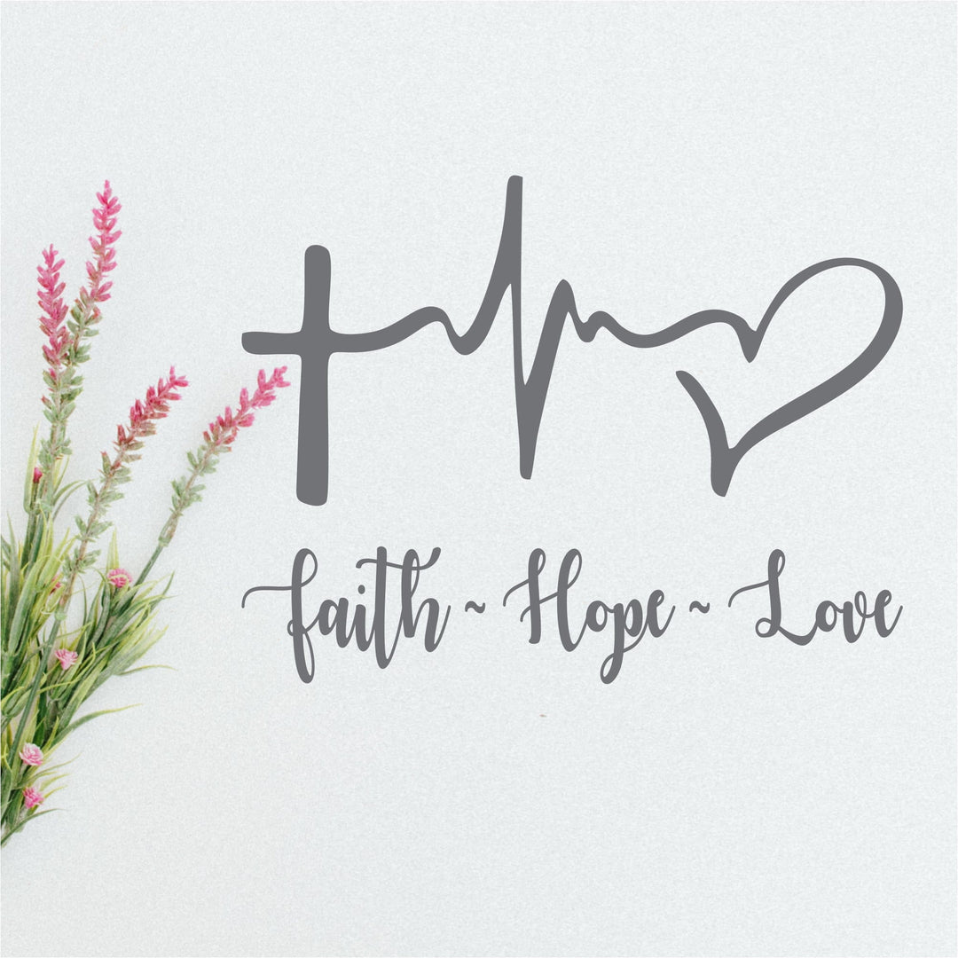 Faith Hope Love decal with a cross, heartbeat line and heart in gray script on a white wall