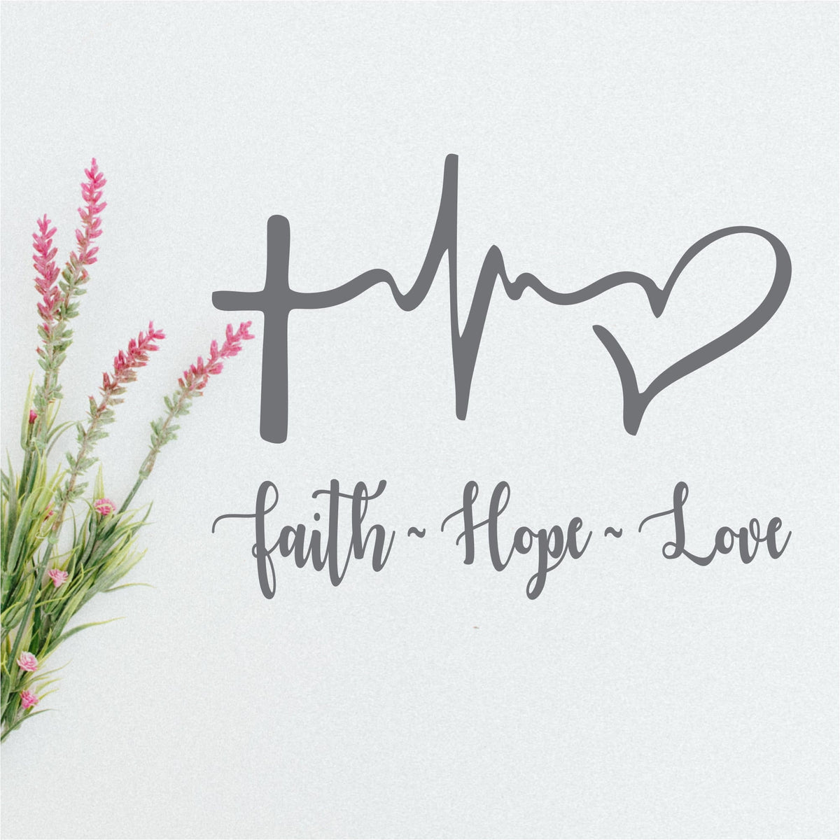 Faith Hope Love decal with a cross, heartbeat line and heart in gray script on a white wall
