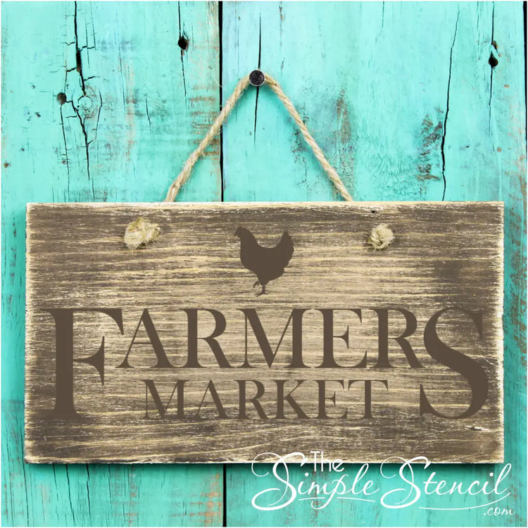 An adorable rustic Farmers Market sign created by using a Simple Stencil decal on an old wooden plank to decorate a farmhouse style kitchen.