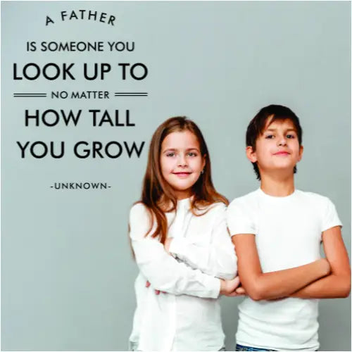 A cute Father's Day wall decal display to celebrate Dad's reads: A father is someone to look up to no matter how tall you grow. -unknown