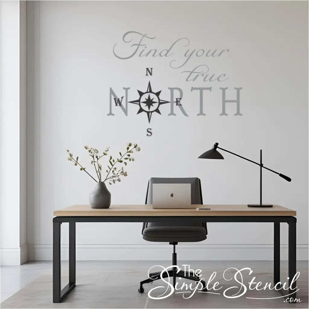 Modern office setup with a desk, chair, laptop, and lamp, featuring a motivational wall decal that reads "Find your true North"