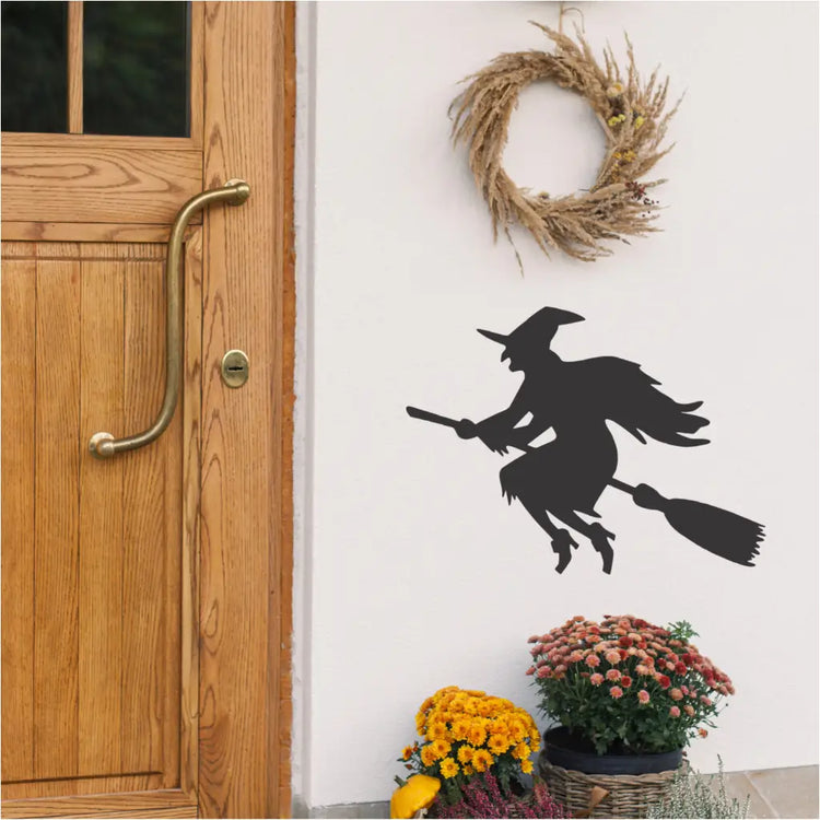 Flying Witch Decal Black: A black silhouette of a witch flying on a broomstick, perfect for Halloween decorations.