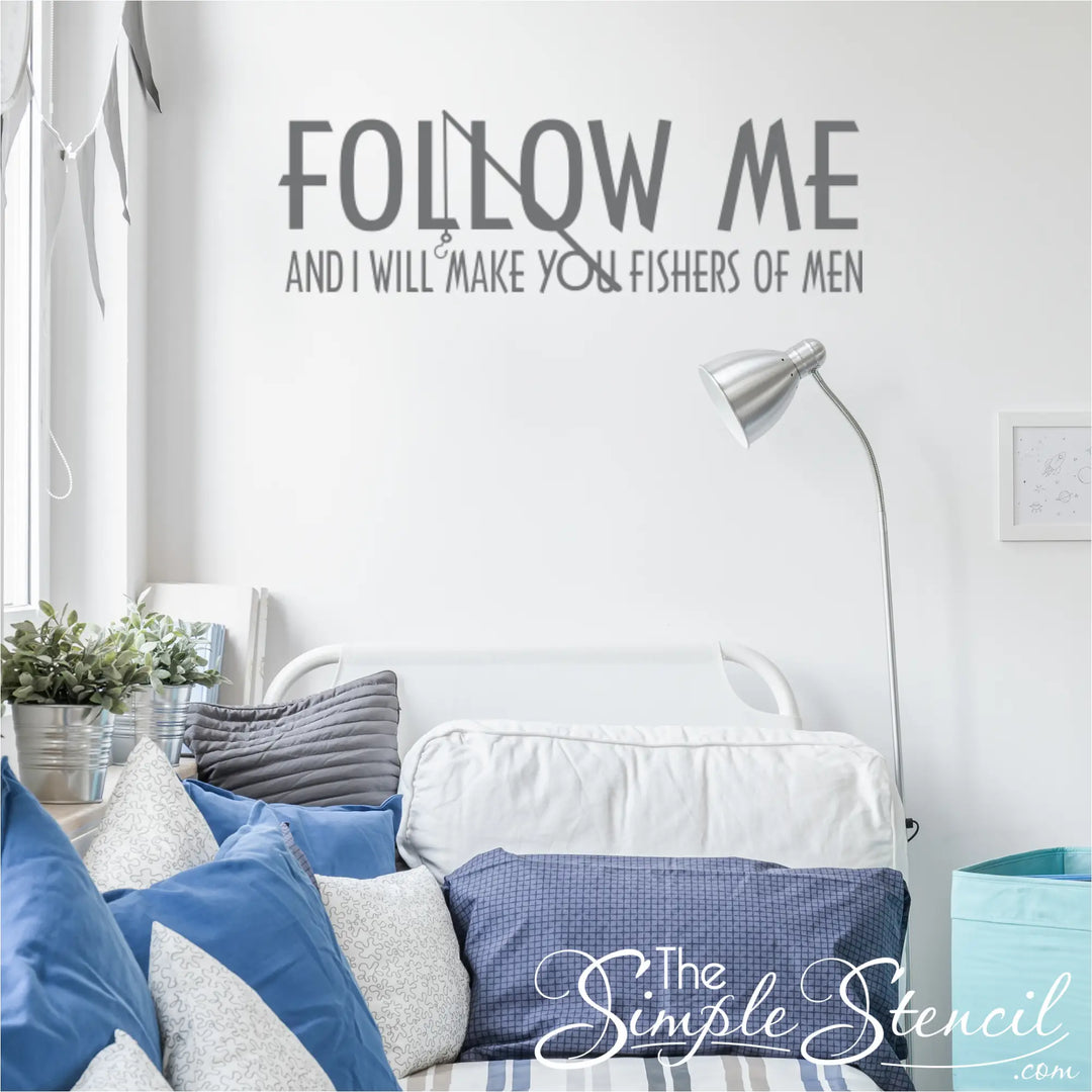 Matte grey Christian fishing-themed wall art decal in a bright teen boy's bedroom, positioned above a white metal bed with blue and grey pillows.