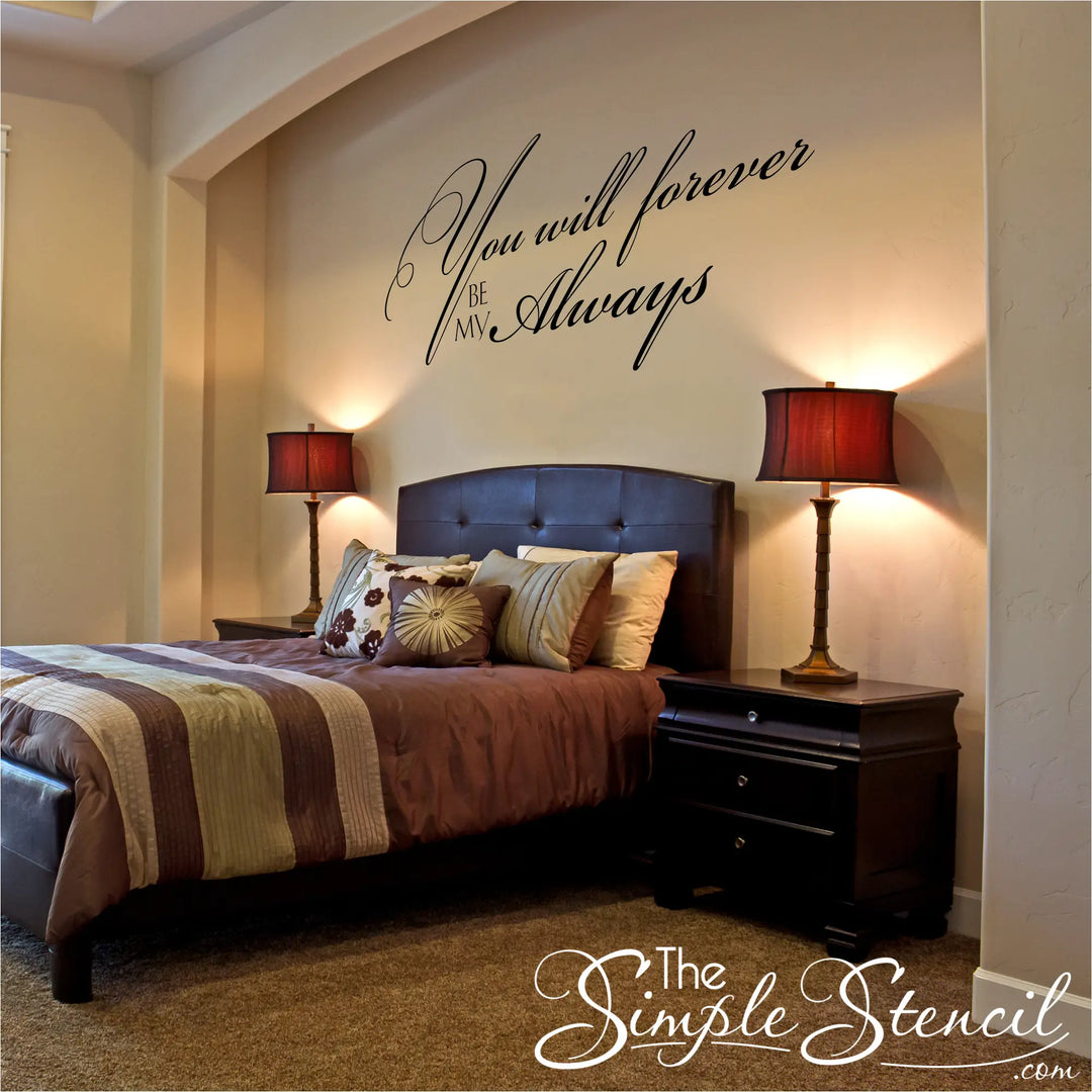 Elegant black vinyl wall decal with the quote "You will forever be my always" in a fancy script font, displayed on a beige wall above a dark leather tufted headboard and matching bedside lamps.