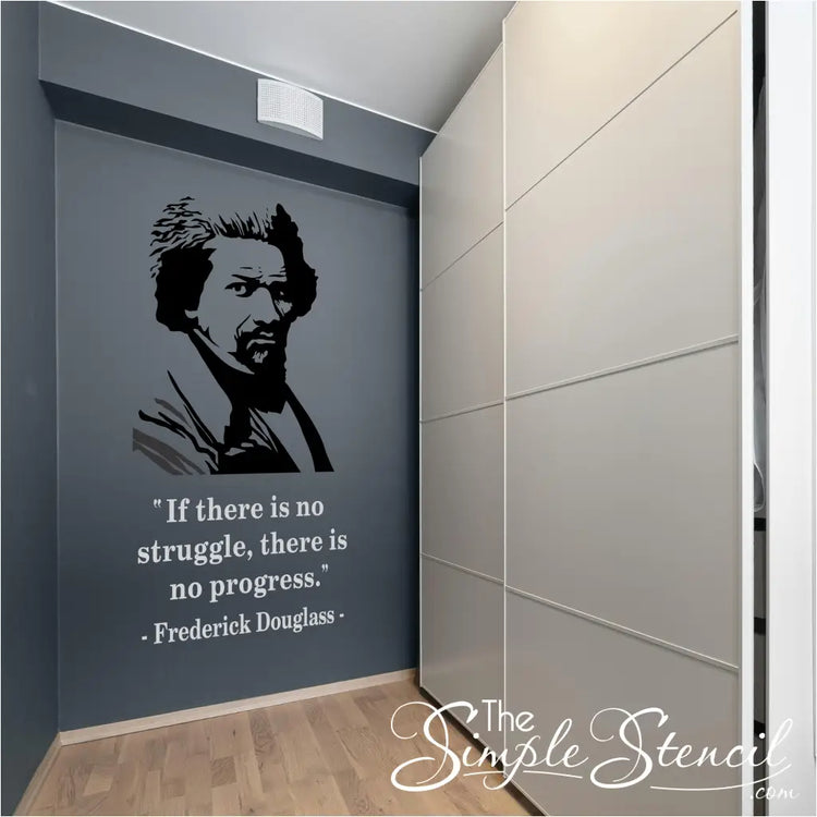 A large-scale Frederick Douglass silhouette and quote decal installed on a dark grey feature wall in a modern building hallway next to white storage cabinets.