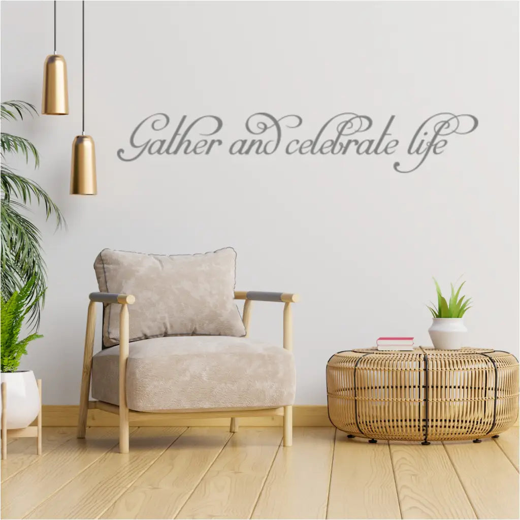 Fancy flourish script "Gather and Celebrate Life" wall decal in a modern living room setting.