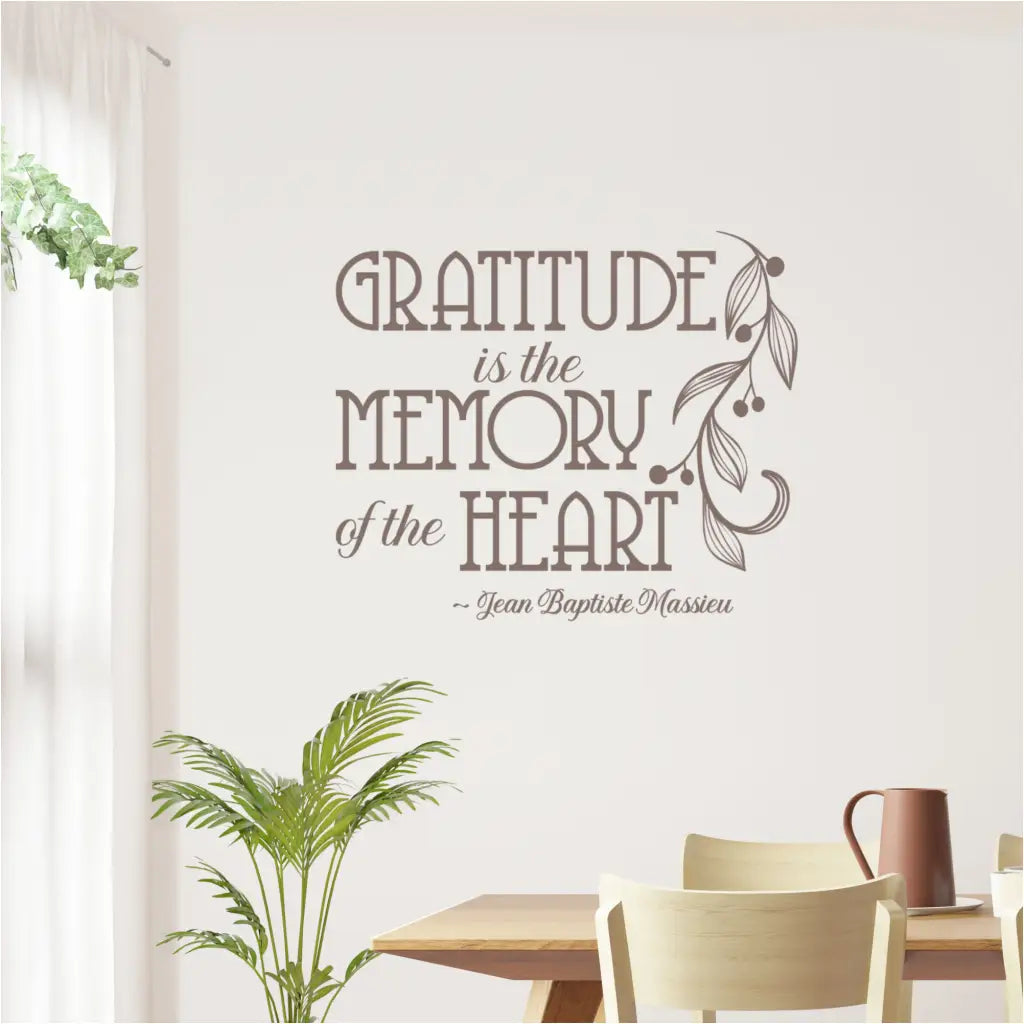 The inspirational French quote wall sticker, "Gratitude is the Memory of the Heart," shown in a bright, casual dining nook with a wooden table.