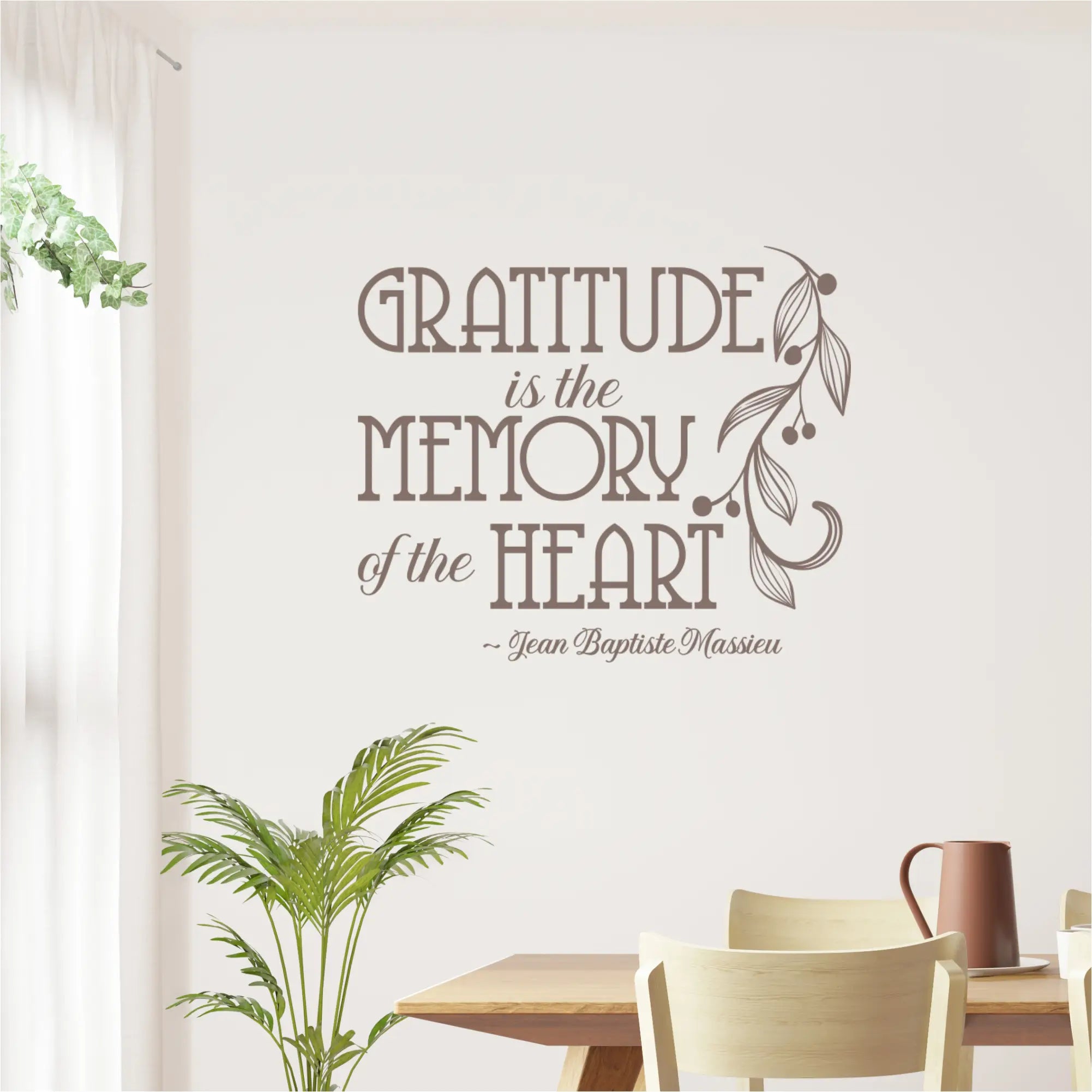 The inspirational French quote wall sticker, "Gratitude is the Memory of the Heart," shown in a bright, casual dining nook with a wooden table.