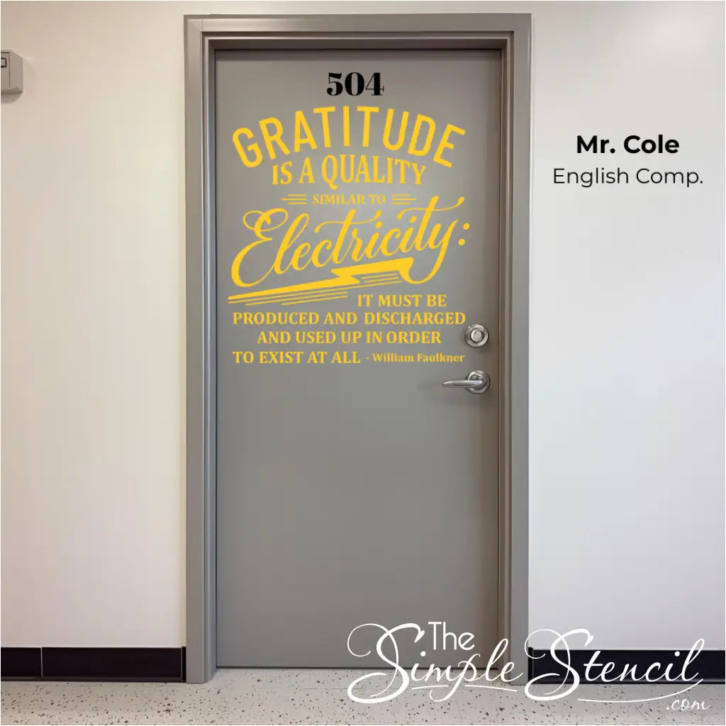 A large yellow wall decal on a gray classroom or office door with the quote "Gratitude is a quality similar to electricity." by William Faulkner. The decal is centered below the room number 504.