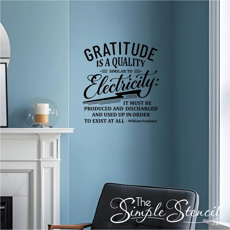 A black wall decal of the quote "Gratitude is a quality similar to electricity..." by William Faulkner, installed on a light blue wall above a fireplace in a cozy living room.