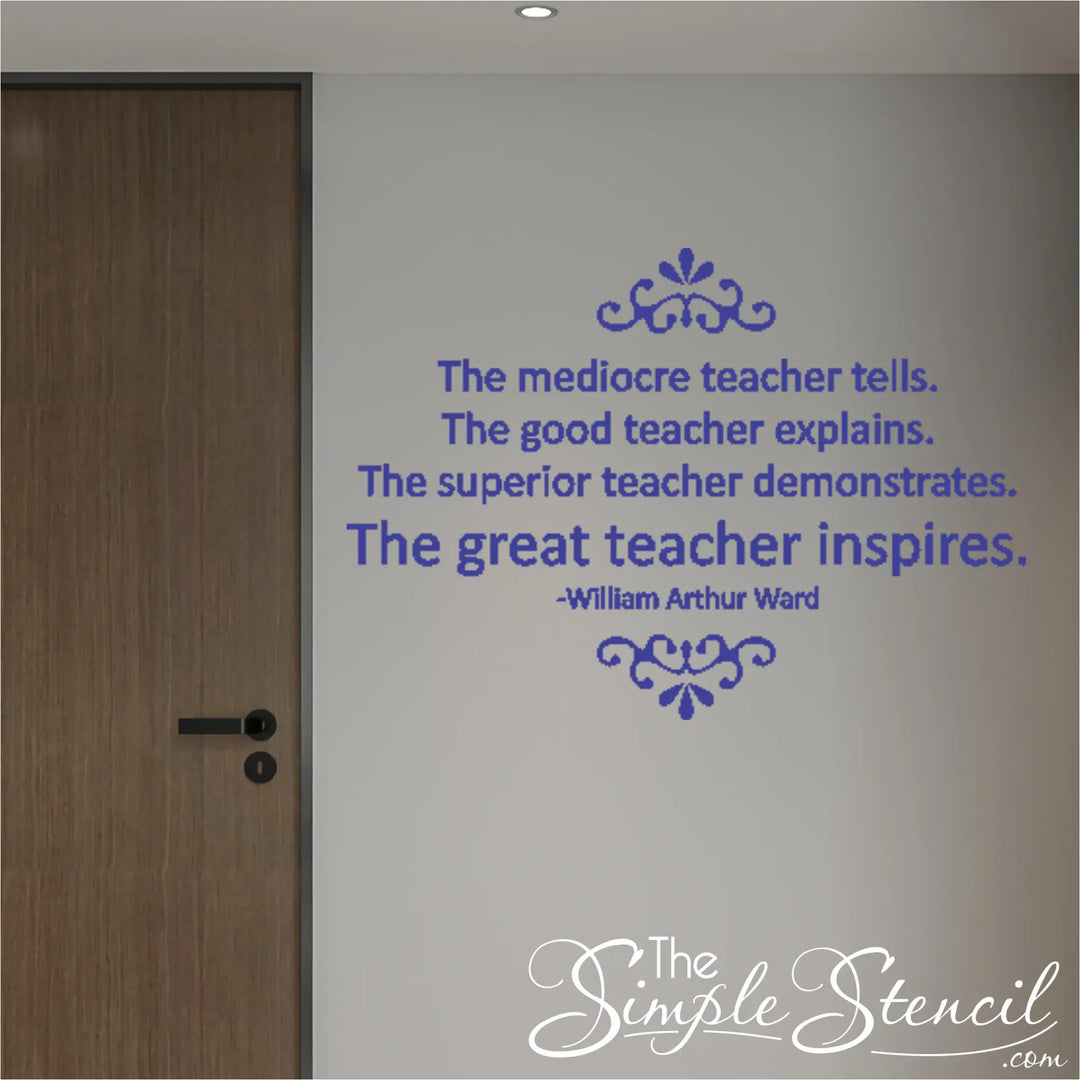 A minimalist school hallway with a dark wood door. A large, royal blue vinyl stencil is applied to the neutral-colored wall, featuring the full William Arthur Ward quote ending with 'The great teacher inspires'.