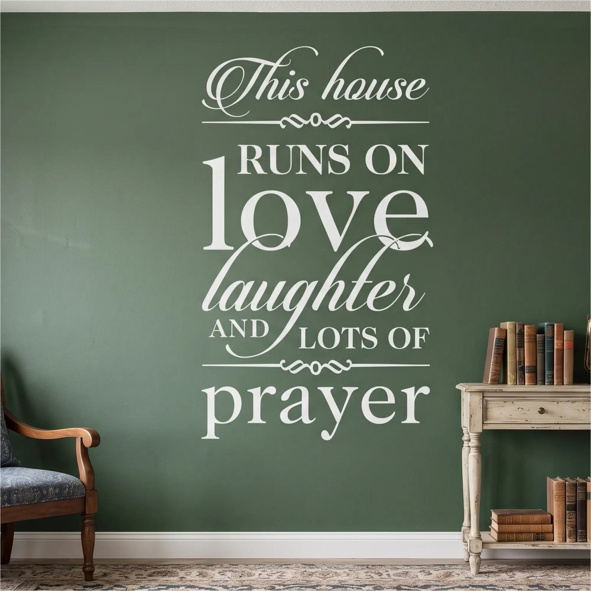 High-contrast white vinyl wall lettering featuring the complete 'This house RUNS ON love laughter AND LOTS OF prayer' scripture coordination design applied flawlessly to a deep forest green textured accent wall above a traditional console table with antique books, providing a sacred, painted-on anchor point for the domestic church.