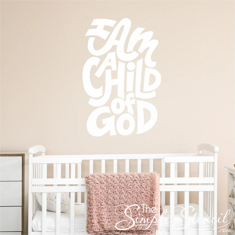 "I am a child of God" wall decal in a sweet baby nursery setting, above a crib, shown in 28.5" size using matte white vinyl by The Simple Stencil