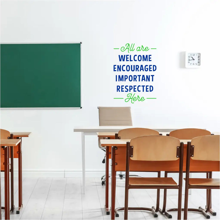 A classroom with the wall decal prominently displayed, to welcome all students that reads: All are welcome encouraged important respected here
