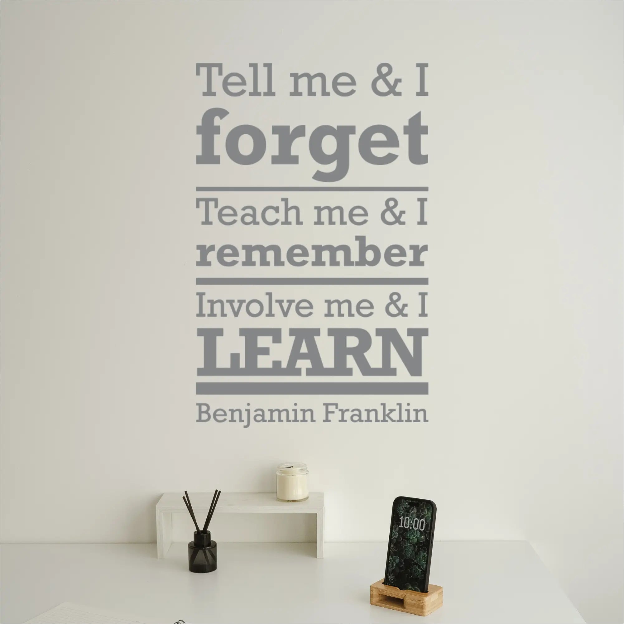 The quote decal displayed on a wall in a teacher's lounge.