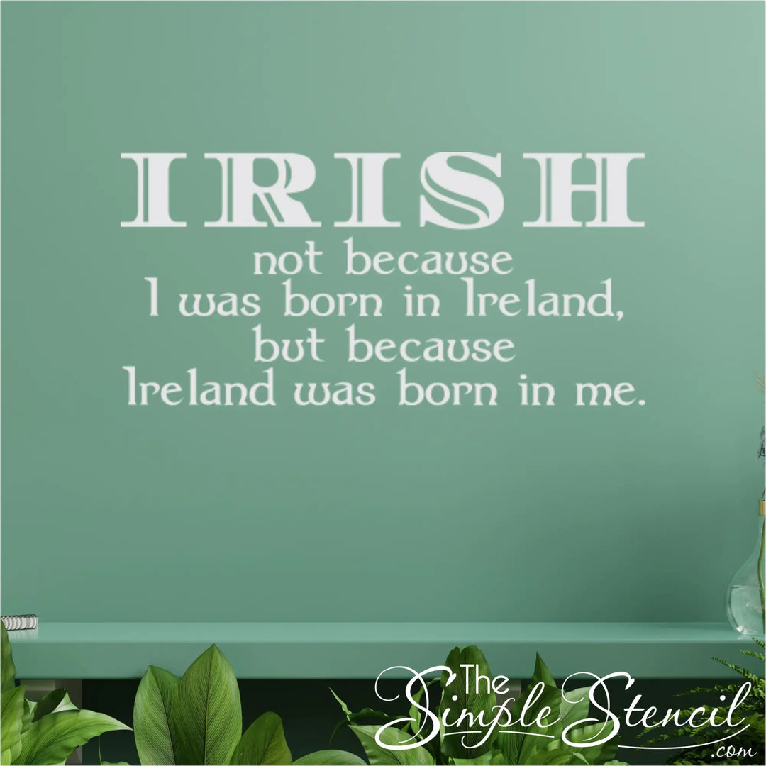 White vinyl Irish blessing decal applied to a muted green accent wall above a shelf with indoor plants, demonstrating a modern approach to seasonal holiday decor.