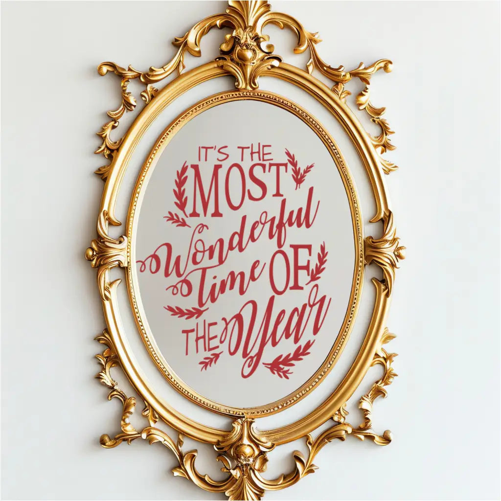 Red Christmas song lyrics vinyl decal on an ornate gold mirror reading 'It's the Most Wonderful Time of the Year.' This holiday mirror sticker features a whimsical scripted font and is perfect for holiday party decor and retail window displays.
