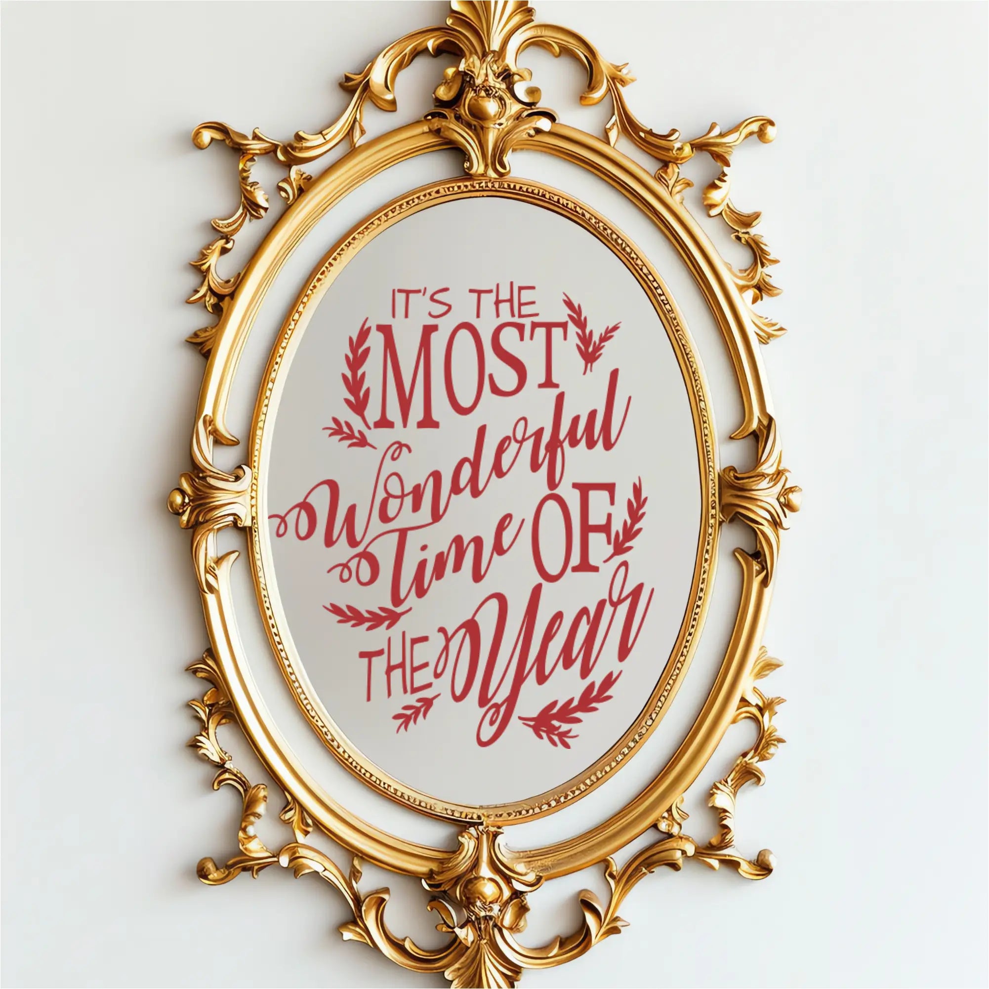 Red Christmas song lyrics vinyl decal on an ornate gold mirror reading 'It's the Most Wonderful Time of the Year.' This holiday mirror sticker features a whimsical scripted font and is perfect for holiday party decor and retail window displays.