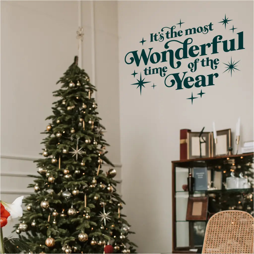 Striking 'It's the Most Wonderful Time of the Year' vinyl wall decal in a deep, sophisticated teal/emerald green color. Applied to a neutral wall above a traditional Christmas tree with gold ornaments. Perfect for modern, elegant holiday styling.