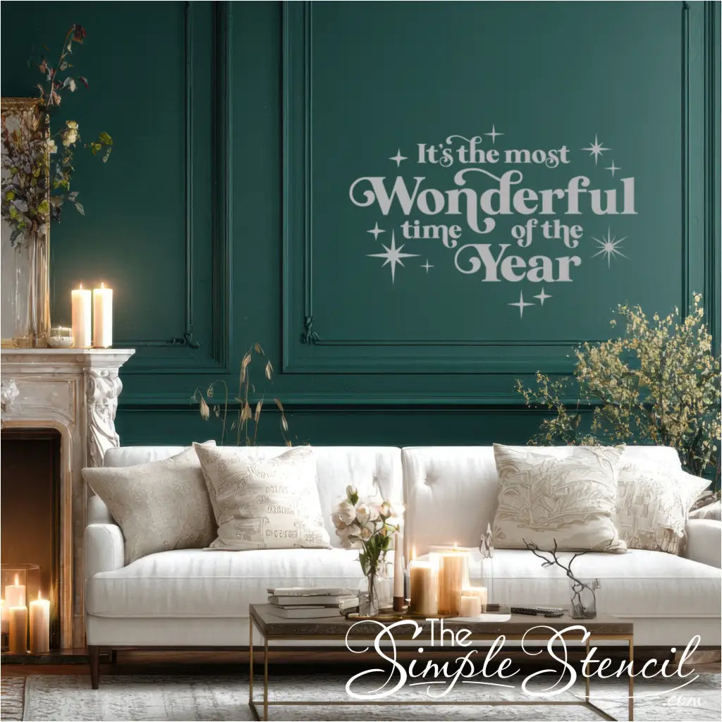 Stunning Christmas wall decor decal, 'It's the Most Wonderful Time of the Year,' applied to a green accent wall above a white sofa. Perfect for creating a cozy, hygge holiday living room atmosphere. Easy application vinyl lettering.