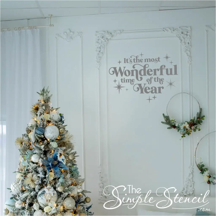 Elegant  silver 'It's the Most Wonderful Time of the Year' vinyl decal on a white wall with ornate trim and a pastel-themed Christmas tree. Shabby chic holiday wall art that complements neutral and subtle decor styles.