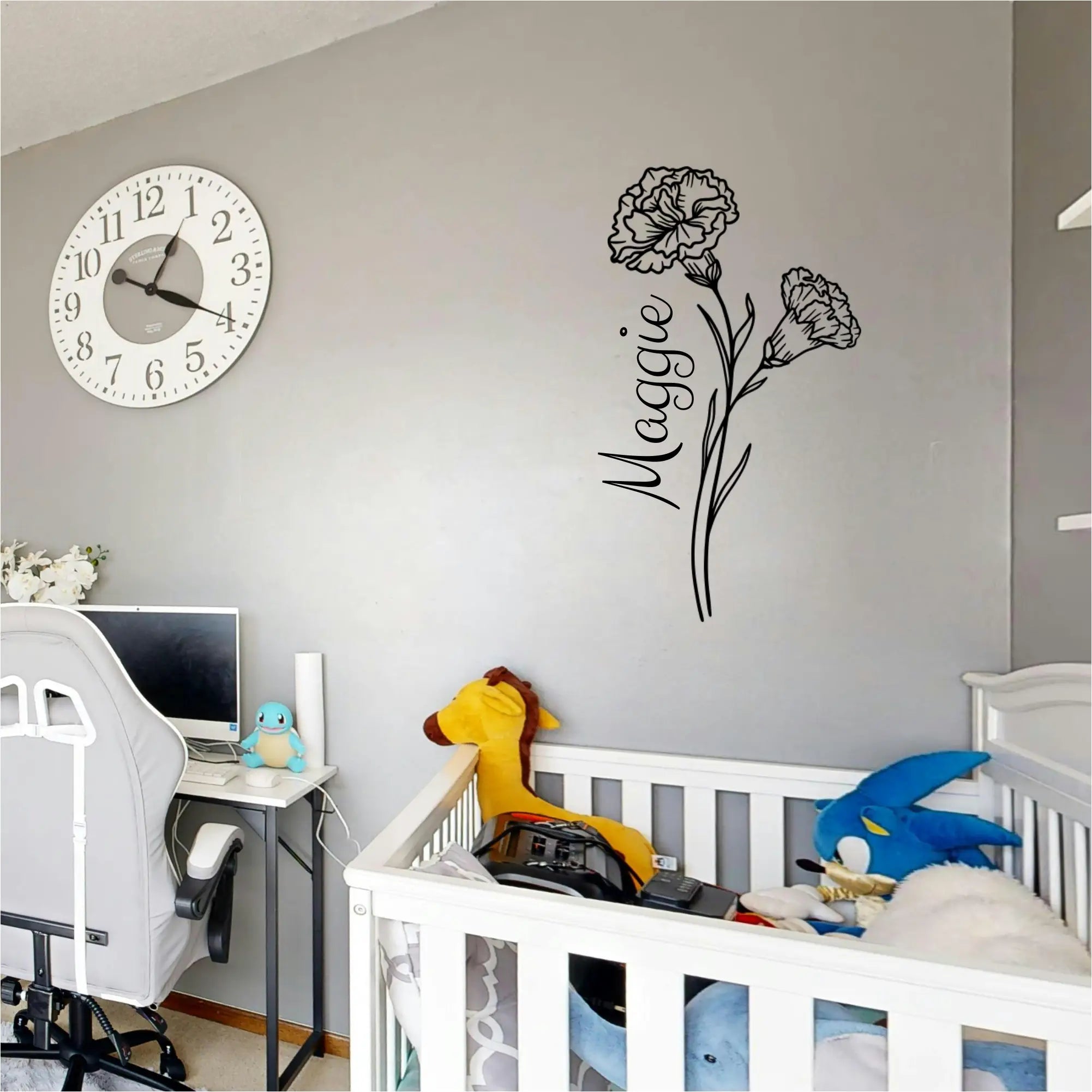 Black Carnation birth flower wall silhouette paired with a custom name decal "Maggie" in a modern, neutral nursery.