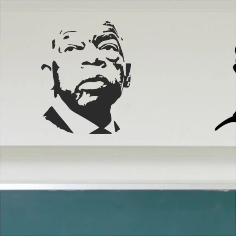 A black vinyl silhouette decal of Civil Rights leader John Lewis featured prominently on the left side of a classroom wall above a green chalkboard, alongside other historical figures.