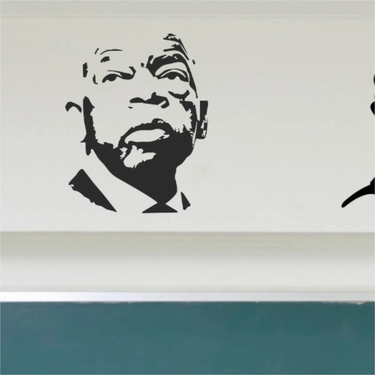 A black vinyl silhouette decal of Civil Rights leader John Lewis featured prominently on the left side of a classroom wall above a green chalkboard, alongside other historical figures.