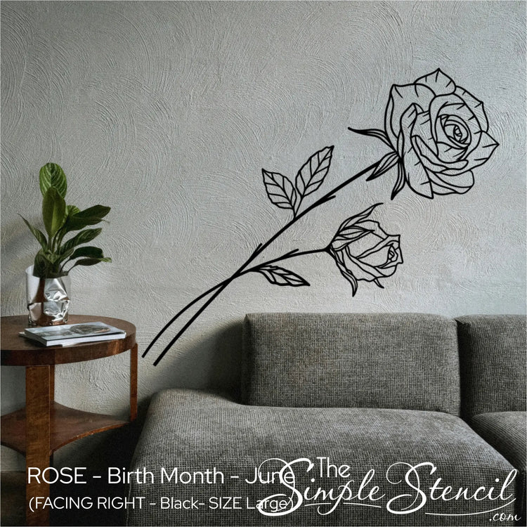Elegant black Rose birth flower wall lettering applied to a textured grey accent wall above a modern sofa.