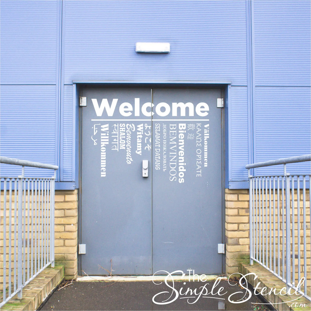 Large Welcome in 15 languages decals installed on two entry doors leading to a gym at a school that frequently hosts foreign students. 