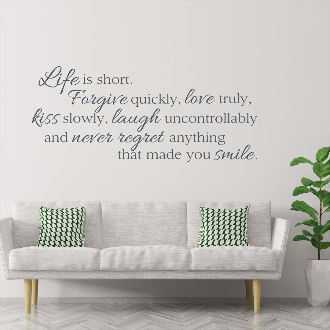 Life is short, forgive quickly, love truly wall quote decal in script above a white sofa