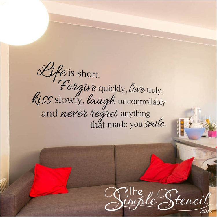 Customer photo of the Life is short wall quote decal in black above a gray sofa with red pillows