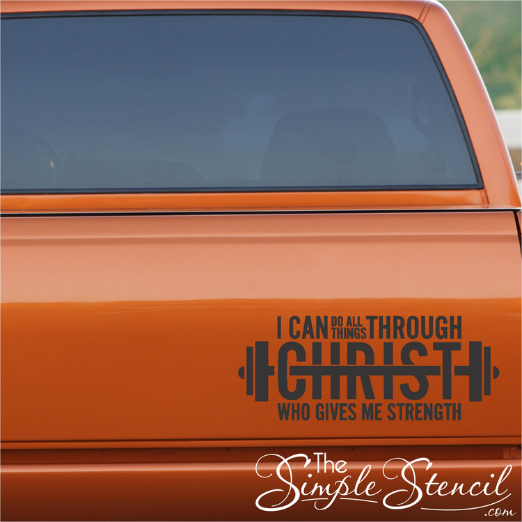 A unique barbell-shaped decal with the scripture "I can do all things through Christ" applied to the back window of a truck, combining faith and fitness.