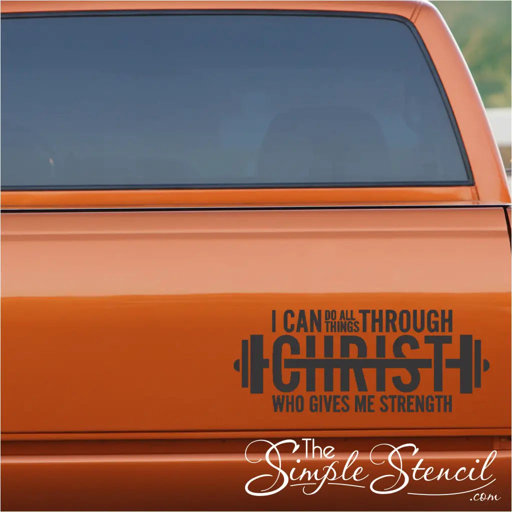 A unique barbell-shaped decal with the scripture "I can do all things through Christ" applied to the back window of a truck, combining faith and fitness.