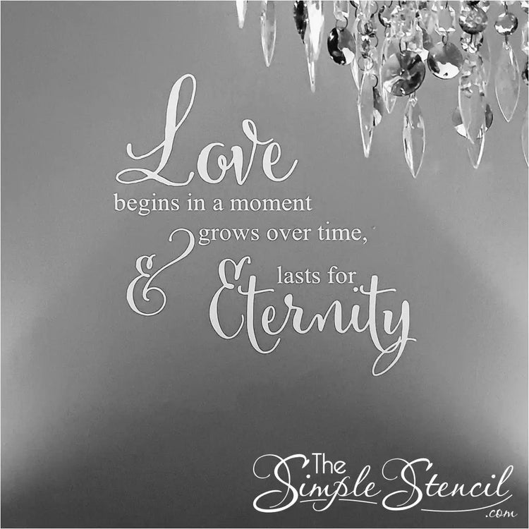 Customer photo of a white romantic wall decal applied near a crystal chandelier, showing the delicate script and high-quality matte finish.