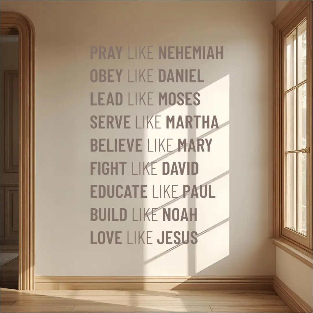 A gray wall decal listing nine biblical virtues and figures, starting with "PRAY LIKE NEHEMIAH," installed on a light beige wall in a sunlit hallway with a wooden floor and a large window.